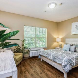 A cozy bedroom with modern decor, featuring a bed, a plant, and a window.