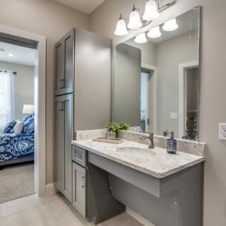 A modern bathroom featuring a sleek vanity with a large mirror and stylish lighting.
