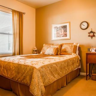 A cozy bedroom with warm-toned decor and a neatly made bed.