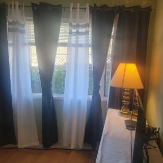 A cozy room with curtains drawn and a warm-lit lamp on the side.