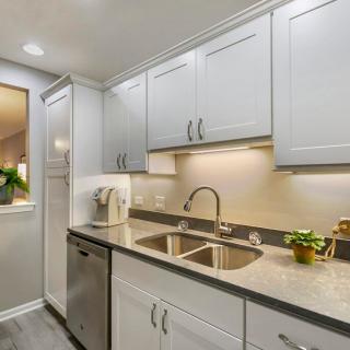 A modern kitchen with white cabinets and stainless steel appliances, showcasing a clean and minimalist design.
