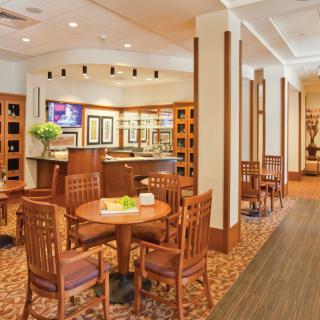 A cozy restaurant interior with wooden tables and chairs, offering a warm and inviting dining atmosphere.
