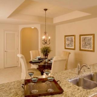 A cozy dining area adjacent to a kitchen, featuring elegant decor and ambient lighting.