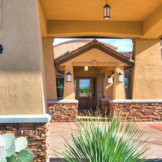 A modern house entrance featuring stone accents and desert landscaping.