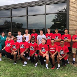 A team of young athletes posing for a group photo outside their training facility.