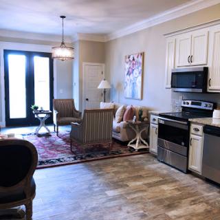 A beautifully designed open-concept living area featuring a cozy seating arrangement and modern kitchen amenities.