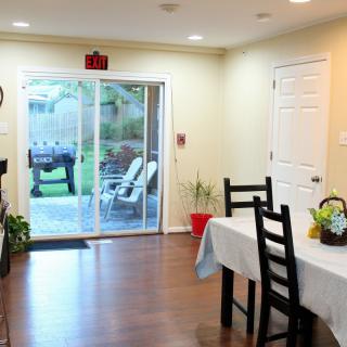 A cozy dining area with a table and chairs, leading to an outdoor patio through sliding glass doors.