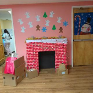 A festive holiday-themed corner featuring a decorated fireplace and cheerful wall art.