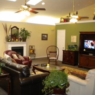 A cozy living room with couches, a fireplace, and a television.
