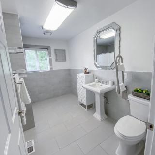 A clean and modern bathroom with white tiles and minimalist decor.