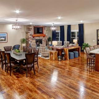 A spacious open floor plan featuring a modern living room and dining area with hardwood floors and cozy lighting.