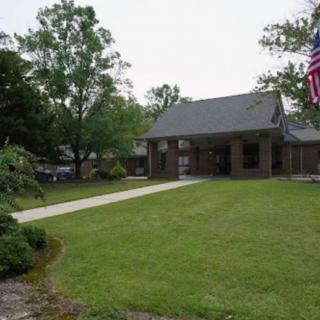 A suburban house with a well-maintained lawn and an American flag displayed in the front yard.