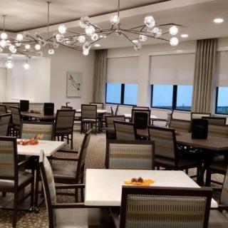 A modern dining area with neatly arranged tables and chairs under stylish lighting.