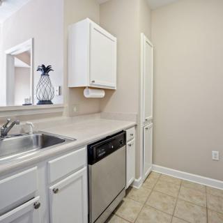 A modern kitchen with white cabinets and a built-in dishwasher.
