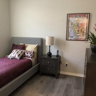 A minimalistic bedroom with a bed, nightstand, and lamp.