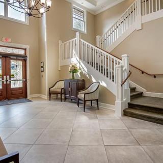 An inviting lobby area featuring a staircase, elegant furniture, and soft lighting.