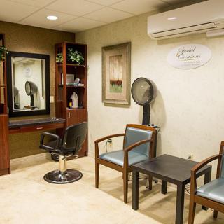 A well-organized hair salon interior with chairs, a mirror, and a hair dryer.