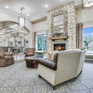 A spacious living room with a modern stone fireplace and elegant furnishings.