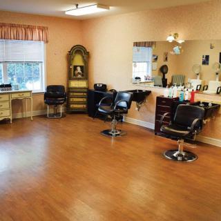An empty hair salon with chairs and mirrors arranged neatly.