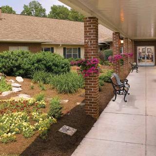 A landscaped garden with a walkway and benches outside a building.