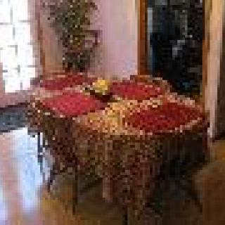 A dining table set with red placemats and a decorative cloth.