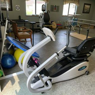 A fitness room equipped with exercise and rehabilitation equipment, including an exercise bike and therapy tools.