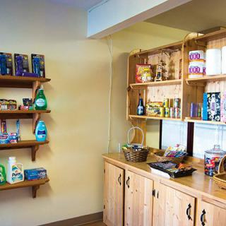 A cozy shop interior with wooden shelves displaying various grocery products.