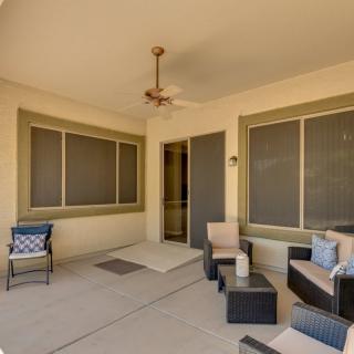 A cozy patio with comfortable outdoor furniture and a ceiling fan.