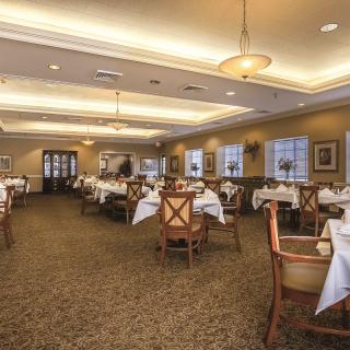 An elegant restaurant dining room with neatly arranged tables and ambient lighting.