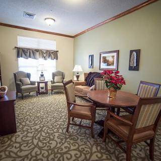 A cozy living room with comfortable seating, a table, and decorative elements.