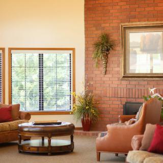 A cozy living room with a brick wall, comfortable seating, and natural light.