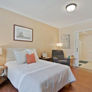 A cozy bedroom with a single bed, armchair, and decorative elements.