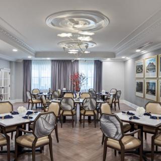 A modern dining room with elegantly set tables and chairs, featuring stylish lighting and decor.