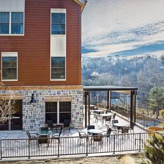 A scenic outdoor patio with tables and chairs overlooking a mountain landscape.