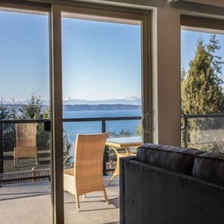 A cozy living room opens up to a balcony with stunning ocean views.