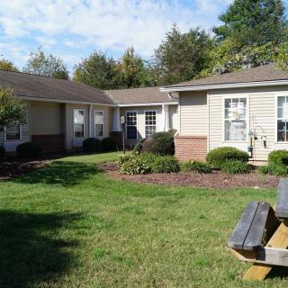 A cozy residential house surrounded by a well-maintained garden and yard.