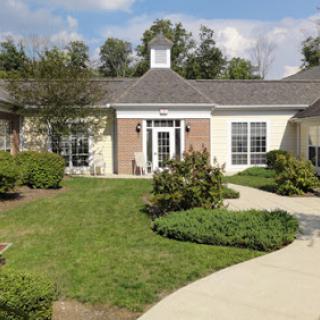 A beautifully landscaped exterior of a building, featuring a well-maintained garden and a winding pathway.