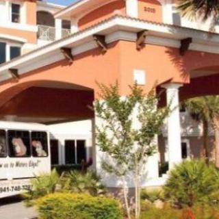 Hotel entrance with shuttle bus parked nearby.