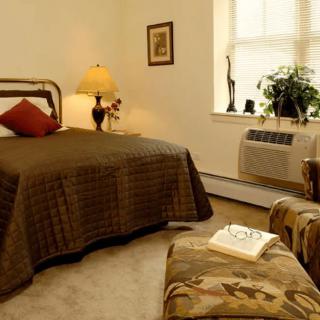 A cozy bedroom with a comfortable bed, lamp, and elegant decor.