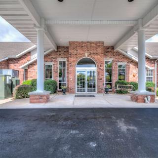 The image shows the entrance of a brick building with a covered walkway.