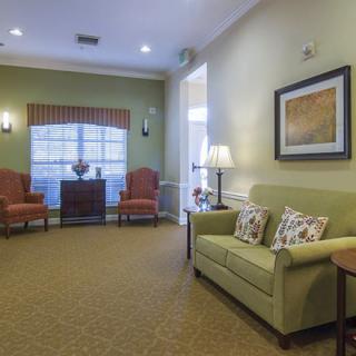 A cozy living room with a sofa, two chairs, and elegant decor.