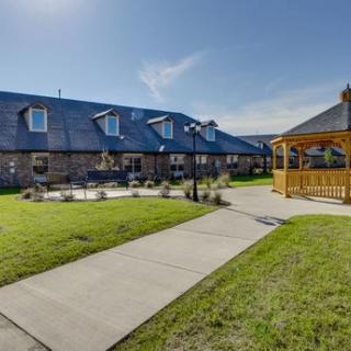 A well-maintained outdoor area featuring a building, garden, and gazebo under a clear sky.