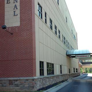 A modern hospital building with a brick faade and connecting walkway.