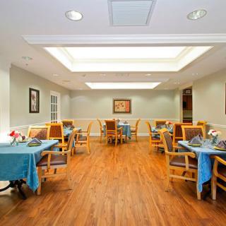 A well-lit dining room with neatly arranged tables and chairs.