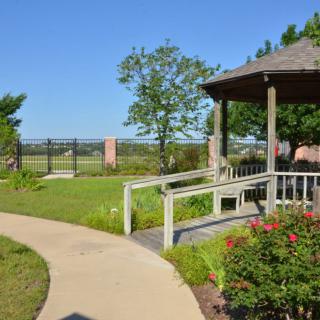 A garden with a gazebo and a winding pathway surrounded by greenery.