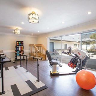 A well-equipped indoor rehabilitation gym featuring fitness equipment and an exercise ball.