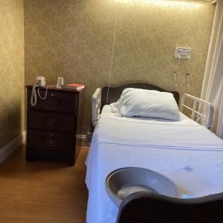 A hospital room with a single bed and medical equipment.