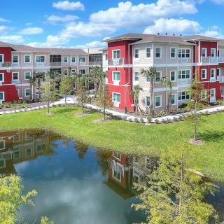 Modern apartment complex with lake view and vibrant architecture.
