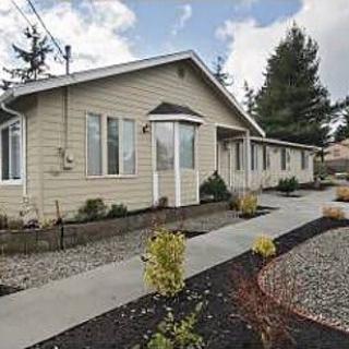 A single-story residential house with a well-maintained yard and pathway.