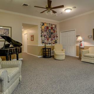 A cozy living room with a piano and comfortable seating.